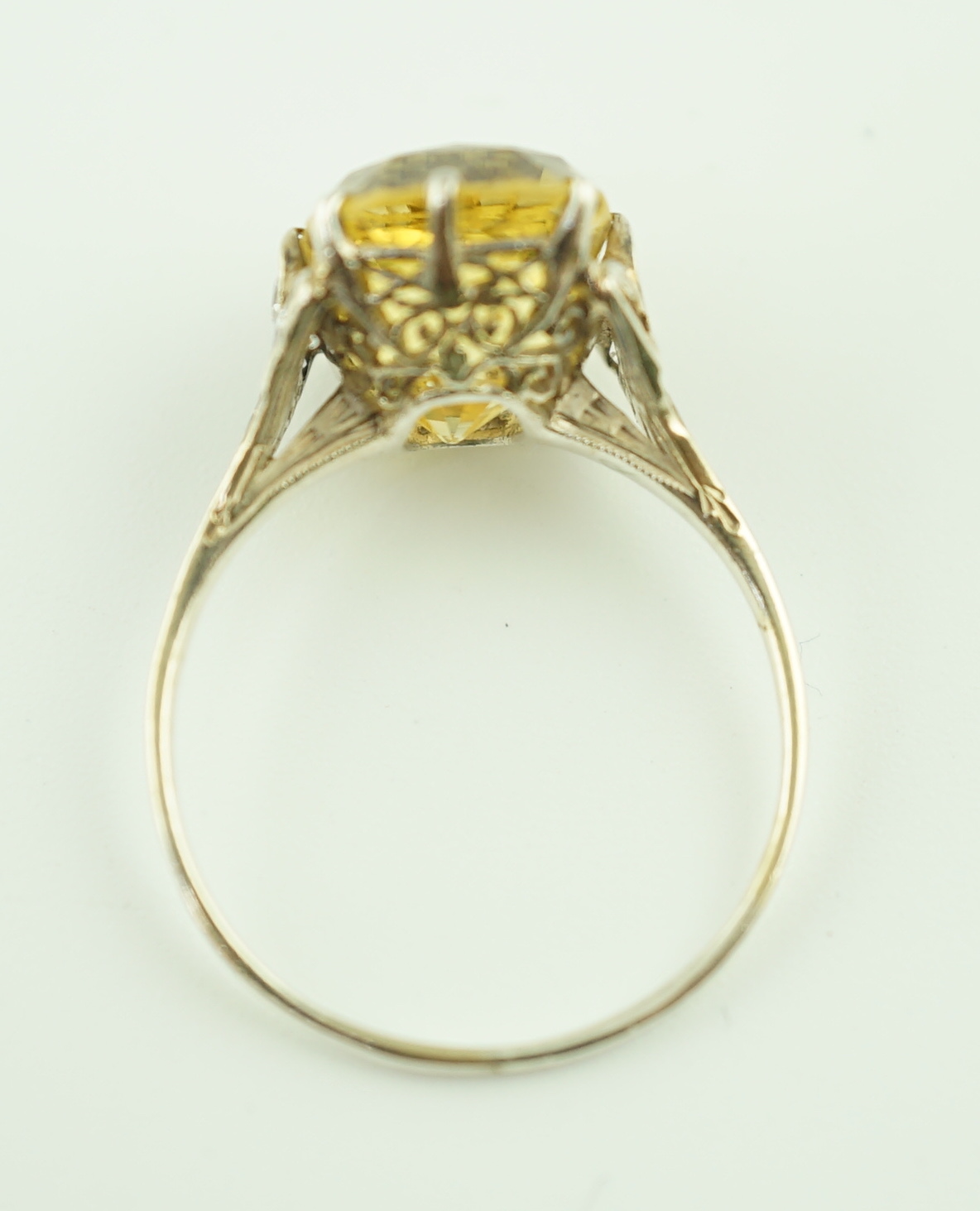 A mid 20th century platinum? and single stone fancy cushion cut yellow sapphire set dress ring with six stone diamond set pierced mount